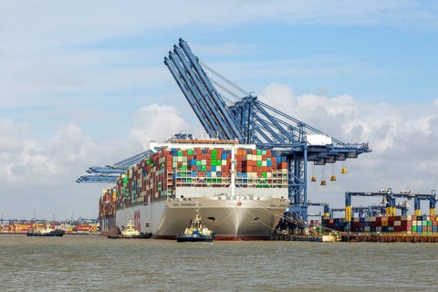 OOCL Zeebrugge container ship at quayside Port of Felixstowe, Suffolk, England, UK tugs arriving to