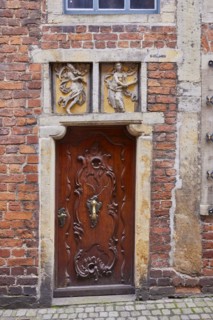 Relief in the lintel and old wooden door of a house in Boettcherstrasse in Bremen, Hanseatic city,