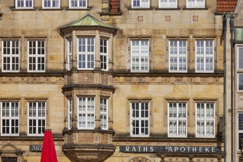 Facade with white windows of the Raths Apotheke and the medical centre on the market square in