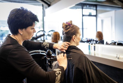 Valentyna Vysotska, hairdresser from Ukraine, combs her customer's hair, taken at the hairdressing