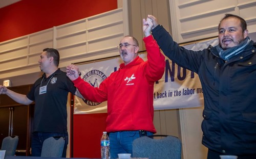 Chicago, Illinois, Shawn Fain (center), president of the United Auto Workers union, joins in