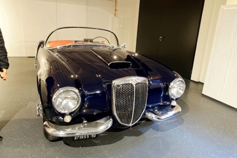 LANCIA AURELIA B24 SPIDER, A black Lancia classic car with elegant chrome details in a showroom,