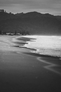 Walk on the beach at sunset, restless sea lapping waves on the beach, rocky landscape in the
