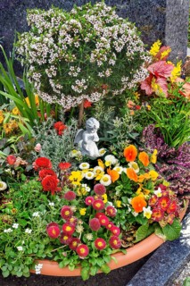 Grave with floral decoration at the cemetery church of St Stephan, Irsee, Swabia, Bavaria, Germany,