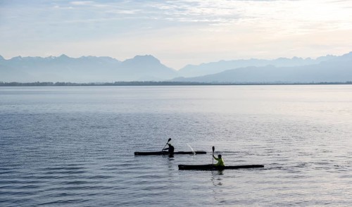 Kayakers paddling in Lake Constance in the evening light, snow-covered mountain peaks, Lindau