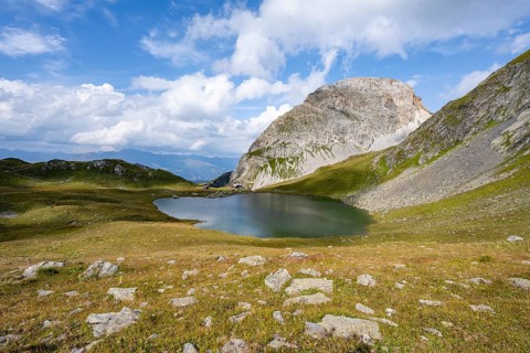 Mountain hut Obstanserseehuette at the mountain lake Obstansersee, behind rocky mountain peak