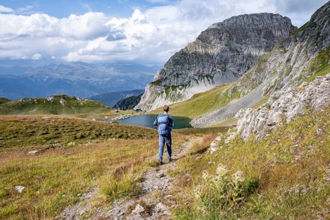 Mountaineer in front of mountain landscape, mountain hut Obstanserseehuette at the mountain lake