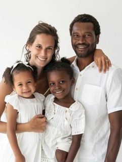 A cheerful multicultural family with two smiling children posing for a portrait, AI generated