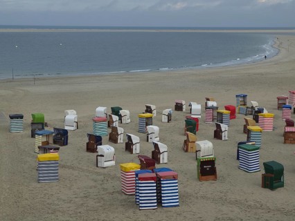 A multitude of colourful beach chairs on the extensive beach with the sea in the background, beach