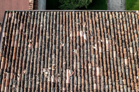 Bird's-eye view of worn terracotta tiles covering residential rooftops