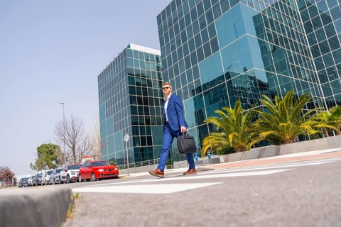 Horizontal full length of a cool elegant caucasian businessman commuting walking along the