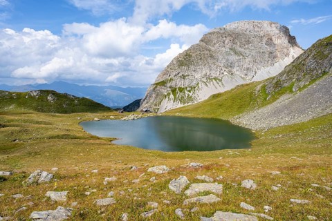 Mountain hut Obstanserseehuette at the mountain lake Obstansersee, behind rocky mountain peak