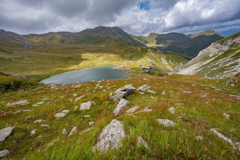 Obstanserseehuette mountain hut on the Obstansersee mountain lake between green mountain meadows,