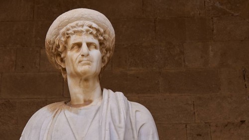 Antique marble statue with headdress and detailed curls, statue from the island of Kos, courtyard,