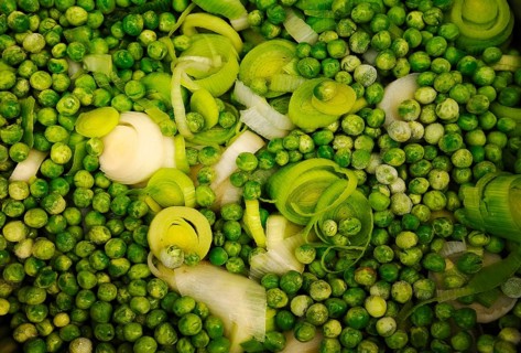 Sliced leek (Allium porrum) and green peas (Pisum sativum)