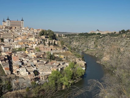 Historic cityscape on the river, architecturally solidly built, surrounded by hills with