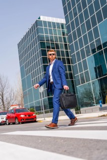 Vertical low angle view of a cool businessman crossing the street in the city