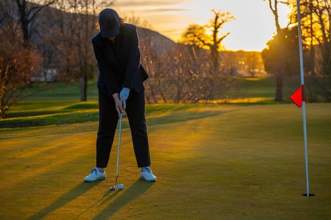 Female Golfer Concentration on the Putting Green on Golf Course in Sunset in Switzerland