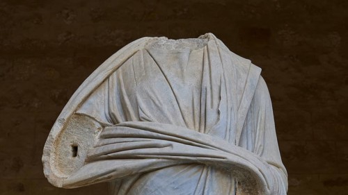 Marble sculpture focussing on the detailed folds of ancient clothing, torso of a Roman statue,