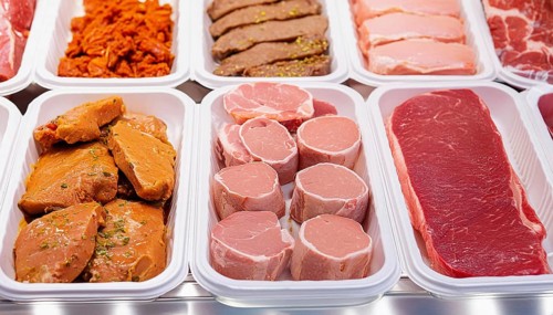 Meat, raw pork, schnitzel and steak, marinated and seasoned, in a display in a butcher's shop, AI