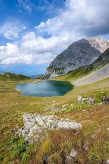 Mountain hut Obstanserseehuette at the mountain lake Obstansersee, behind rocky mountain peak