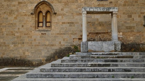 Weathered columns and steps of an ancient ruin with visible stone structure, early Christian