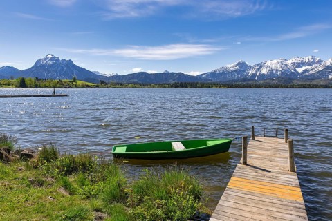 Jetty with boat on Lake Hopfensee, fishing boat, Allgaeu Alps, Hopfen am See, snow, Ostallgaeu,