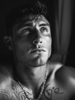 Black and white portrait of a contemplative man with tattoos, AI generated