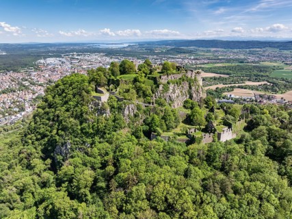 Aerial view of the Hohentwiel volcanic cone with Germany's largest fortress ruins, behind it the