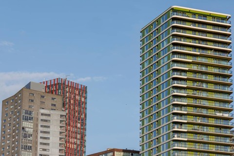 Modern skyscrapers with red and green elements, clear sky, skyline of a modern city on the river