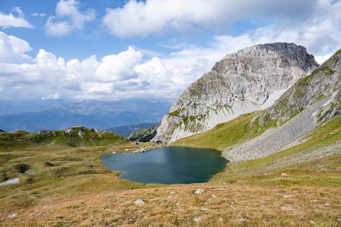 Mountain hut Obstanserseehuette at the mountain lake Obstansersee, behind rocky mountain peak