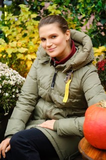 Outdoor portrait of cute mid age woman among autumn flowers