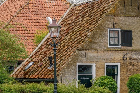Quiet village street with characteristic brick houses and nostalgic street lamp, old houses with