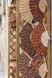 Colorful handmade fans typical of spain displayed in a store in the street