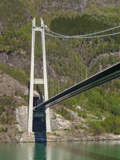 Close-up of a large bridge crossing a wide river and through rocky mountain landscapes, bridge in a