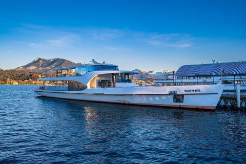 Modern boat on Lake Lucerne with mountains in the background under a blue sky, Lucerne,