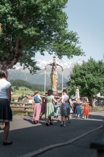 A procession with a statue of the Virgin Mary and traditionally dressed people. Nauders, Austria,