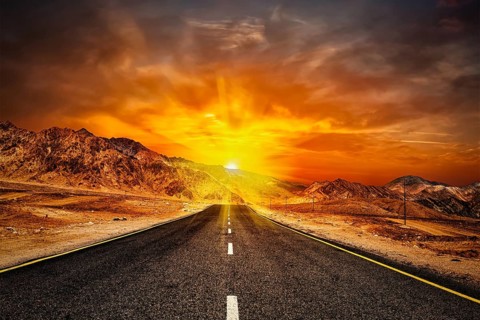 Travel forward concept background, road in Himalayas with mountains and dramatic clouds on sunset.