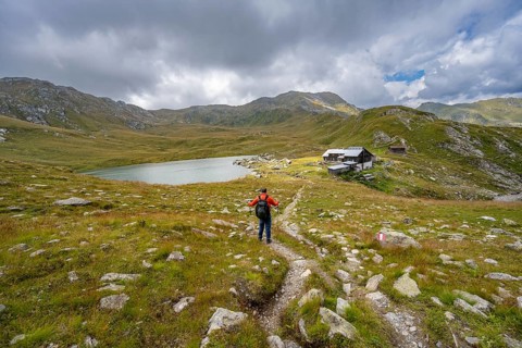 Mountaineer on a hiking trail to the mountain hut Obstanserseehuette at the mountain lake
