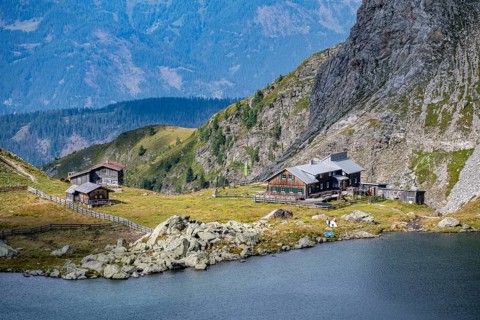 Obstanserseehuette, Obstansersee mountain lake between green mountain meadows, Carnic main ridge,
