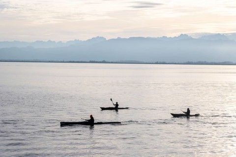 Kayakers paddling in Lake Constance in the evening light, snow-covered mountain peaks, Lindau