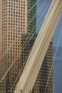 Cityscape with modern skyscrapers and a bridge element in the foreground. Bright blue sky, skyline