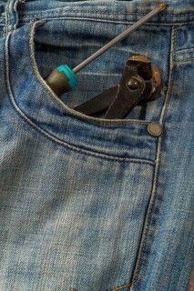 Jeans with a screwdriver and pliers sticking out of the pocket