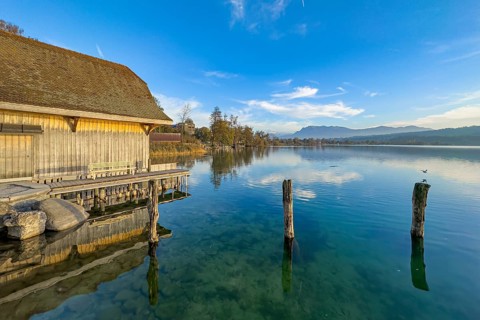 Boathouse on Lake Sempach with reflection in the water and clear sky, Sempach, Lucerne,