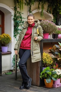 Cute woman posing next to autumn bouquet of colorful flowers at the open farm market