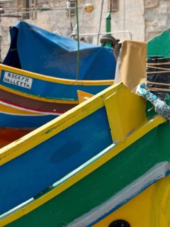 Colourful painted fishing boats in a mediterranean harbour area with name sign 'ROCKY JOE