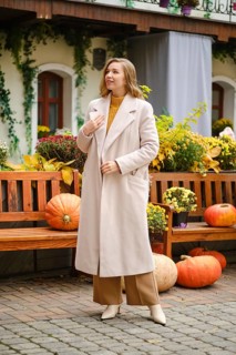 Young woman with unfastened coat at pumpkin festival