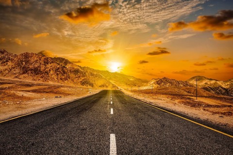 Travel forward concept background, road in Himalayas with mountains and dramatic clouds on sunset.