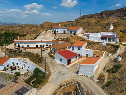Aerial view of a hilltop village with white houses and orange-coloured roofs, aerial view, cave