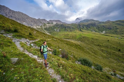 Mountaineer on a hiking trail in the upper Leitner valley, rocky mountain ridge Cresta della